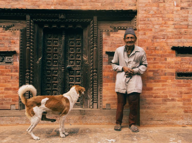 Elderly Man Standing With Dog 