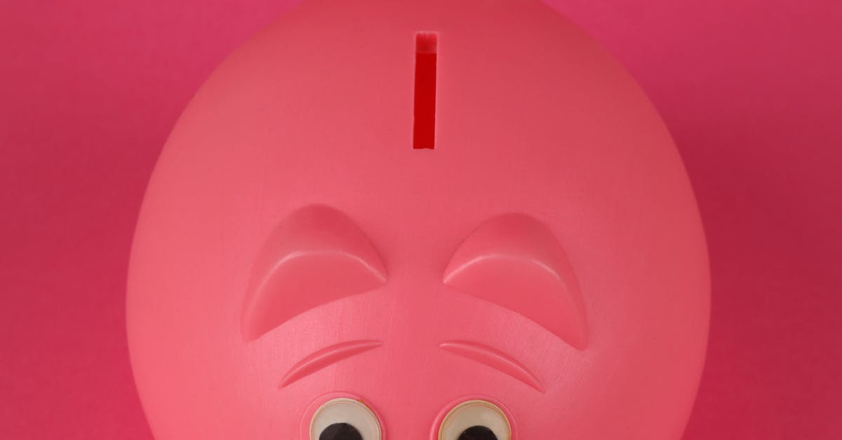 Photo by Ann H Close-up photo of a pink piggy bank on a vibrant pink background, symbolizing savings and finance.