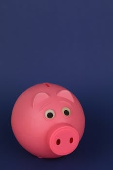 Close-up of a pink piggy bank with a dark blue background, symbolizing savings and finance.
