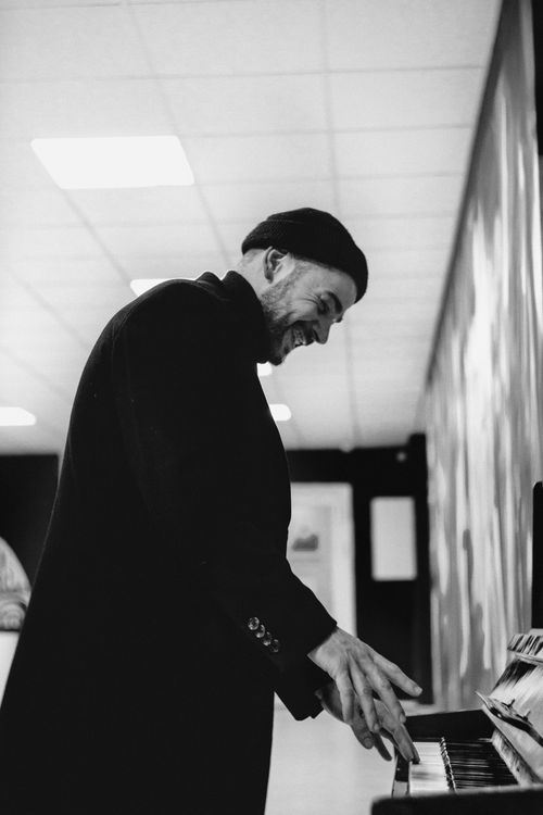 Free Side view of a musician playing piano indoors in a monochrome setting. Stock Photo