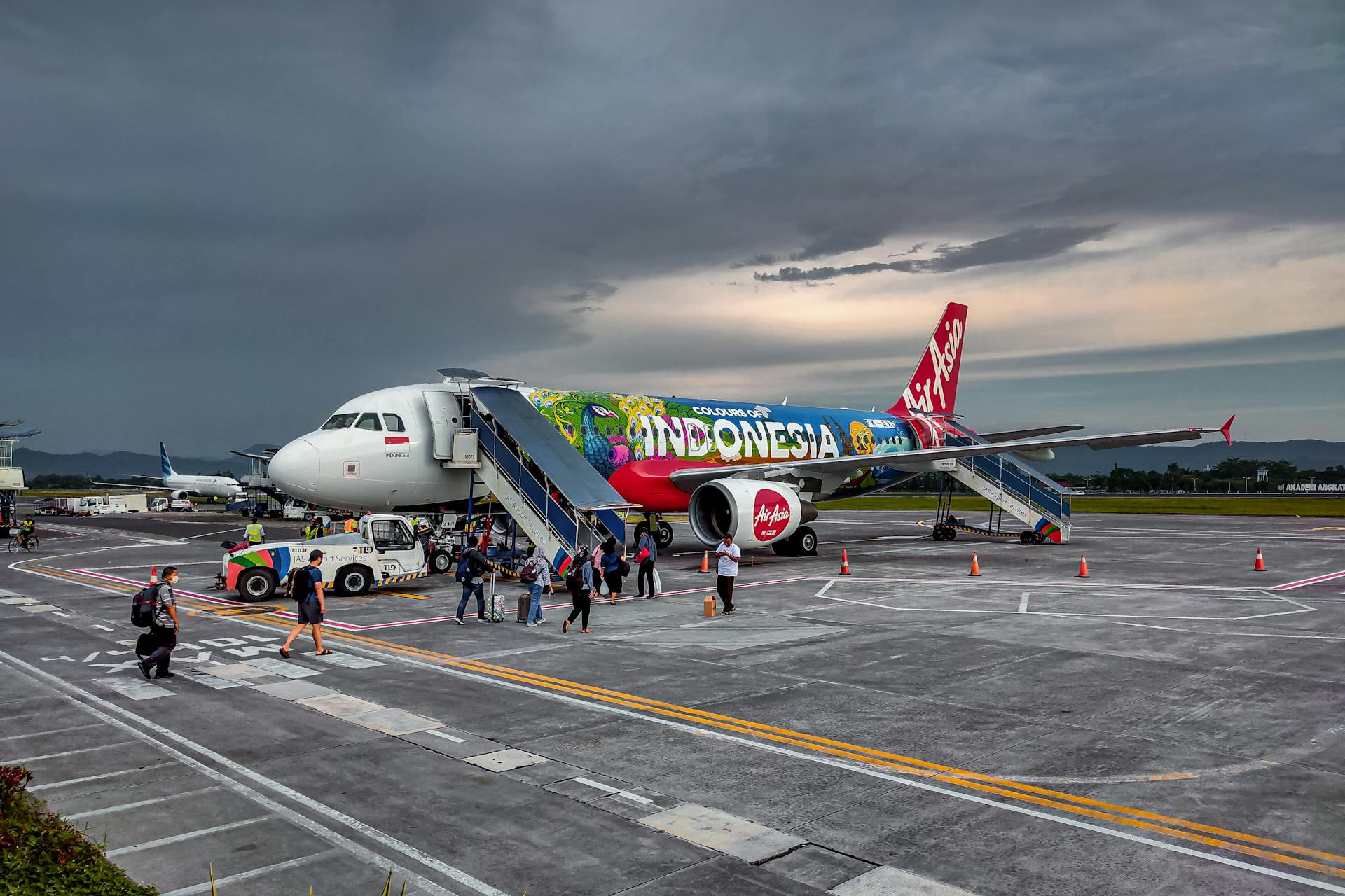 Vibrant Air Asia aircraft with Indonesia-themed livery at Jogja Airport, capturing the essence of travel.