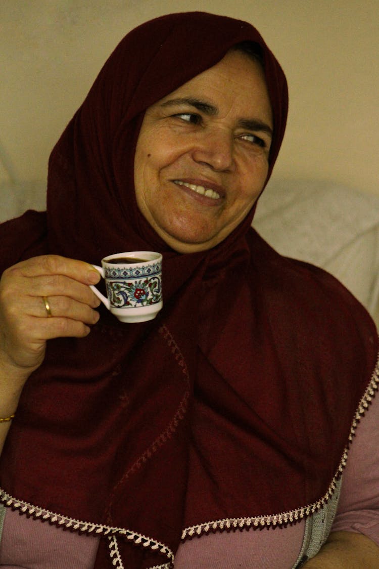 A Woman In Hijab Drinking Coffee