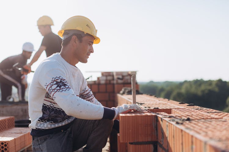 Brick Workers At Construction Site 