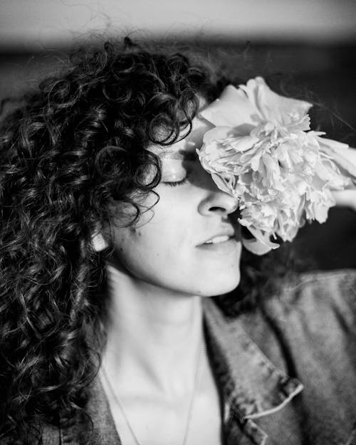 Grayscale Photo of a Woman With Flower on Face