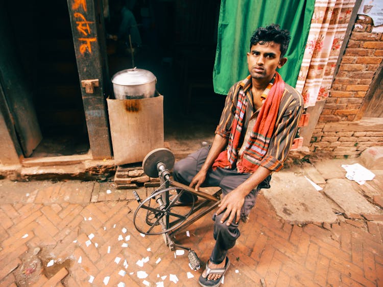 Man Sitting On A Pedal Grinding Wheel