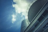 从低角度动态拍摄的现代摩天大楼，玻璃外墙映衬着蓝天