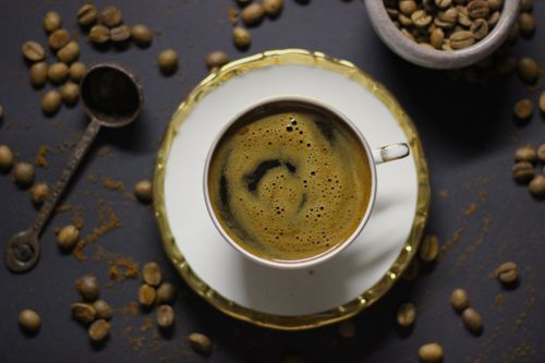 Free Rich and aromatic Turkish coffee in a cup surrounded by coffee beans and ground coffee. Stock Photo