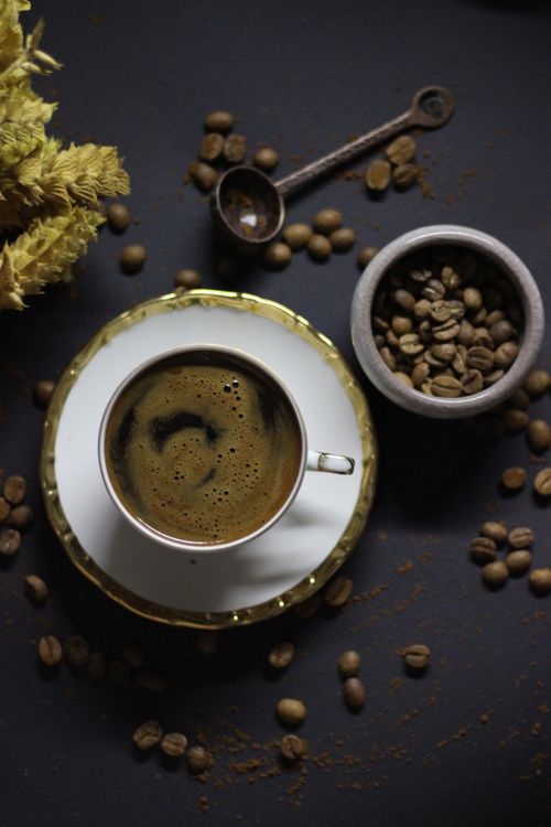 Free A stylish overhead shot of black coffee with beans and a scoop, perfect for coffee-themed uses. Stock Photo