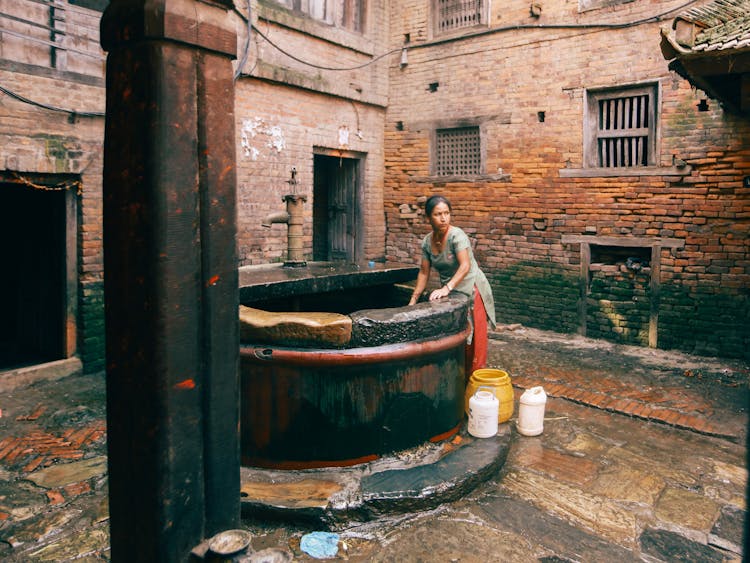 Woman Standing Next To A Well