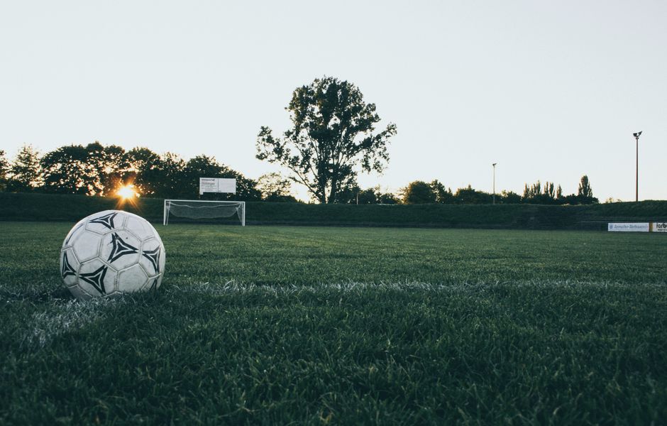 Soccer ball on a stadium pitch at sunset