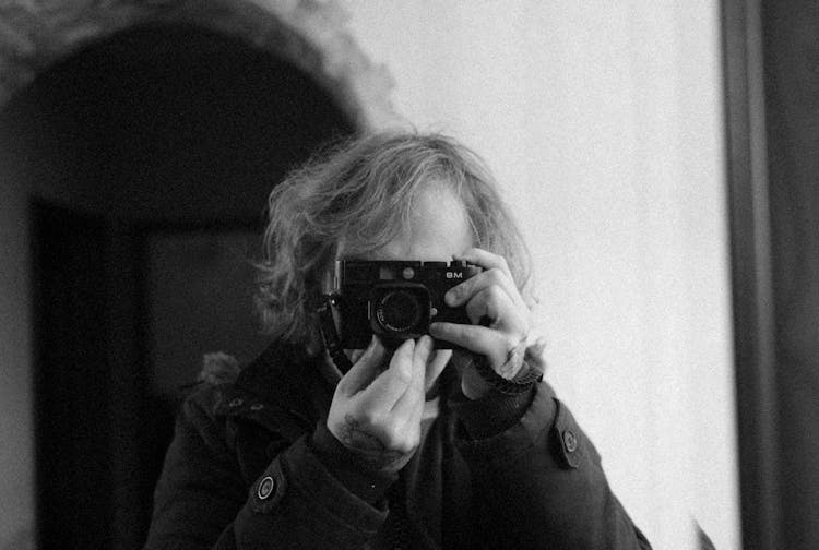 Grayscale Photo Of A Woman Using A Vintage Camera