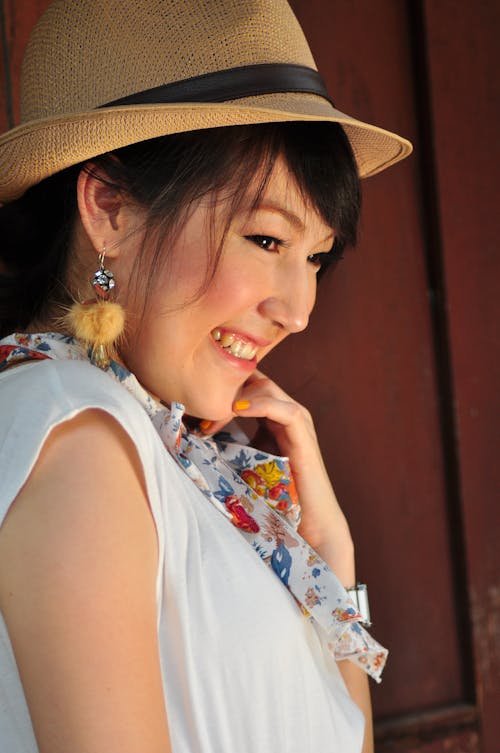 A Woman in Blue Sleeveless Shirt Wearing a Brown Hat