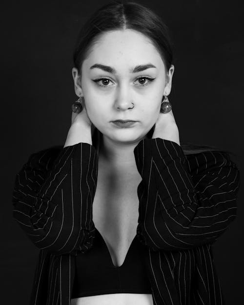 A Grayscale Photo of a Woman Holding her Neck