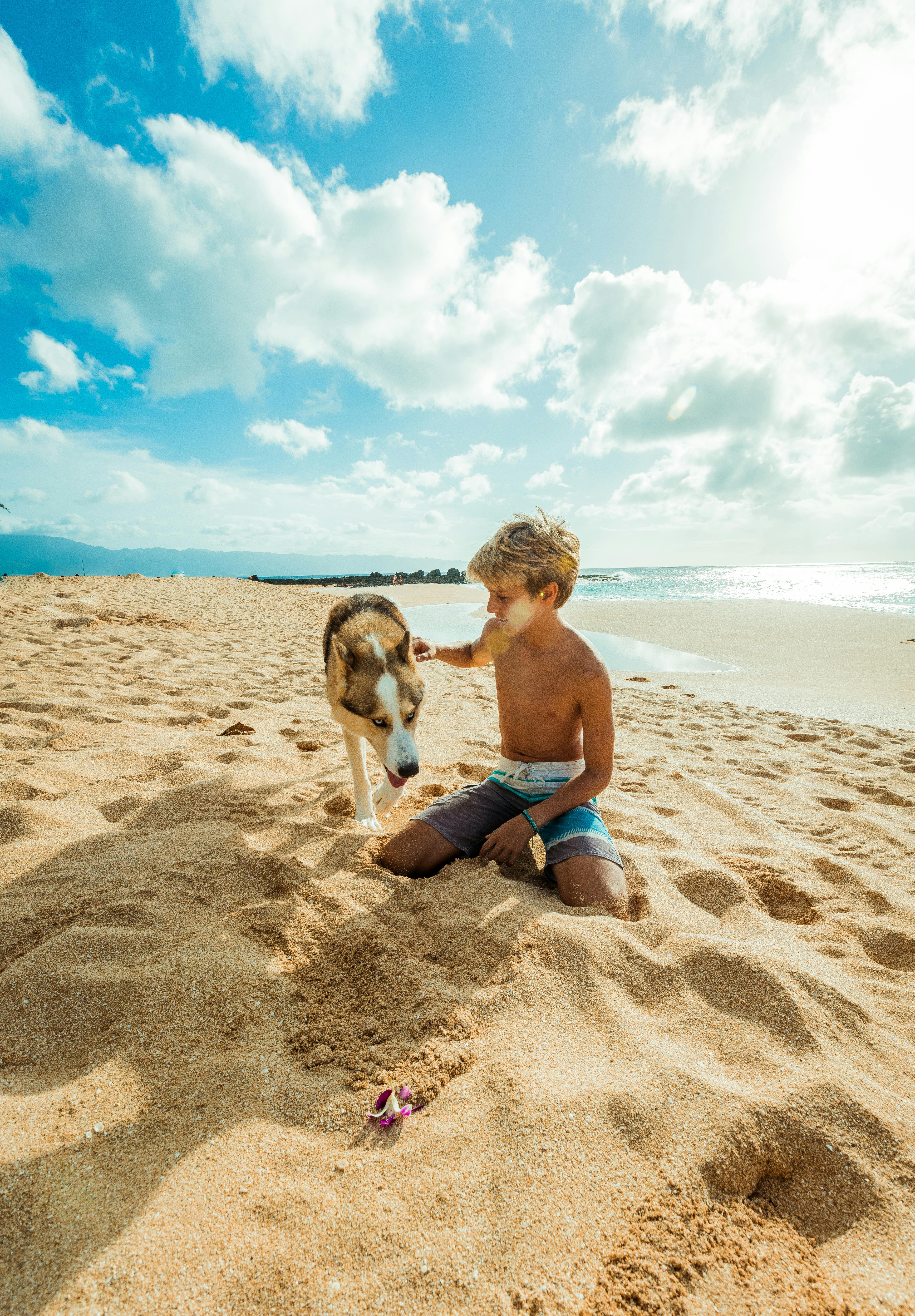Teenage boy and his dog at the beach. | Photo: Pexels