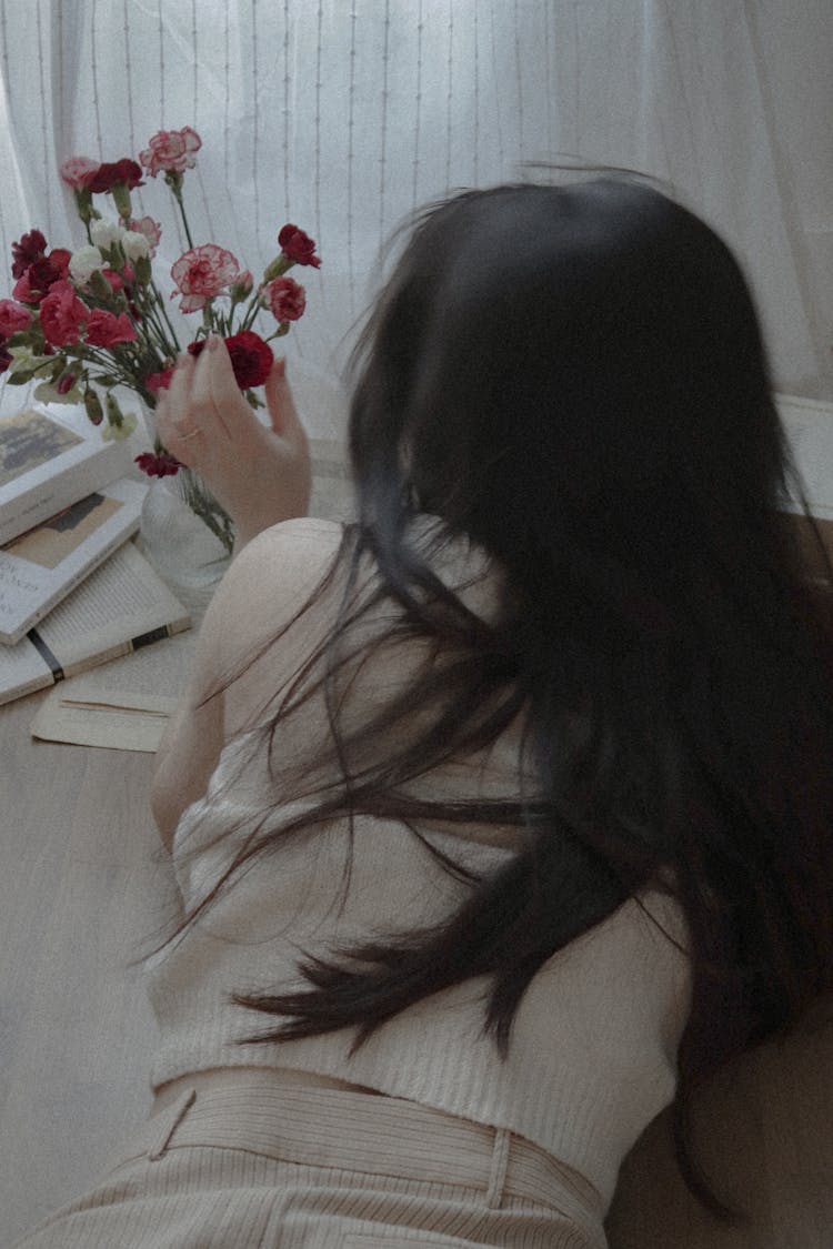 A Woman Touching A Flowers