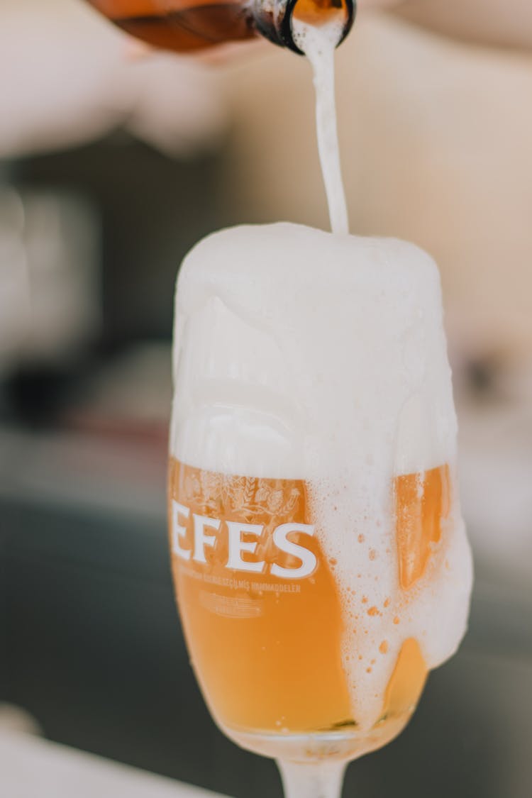 Pouring Beer On Wine Glass