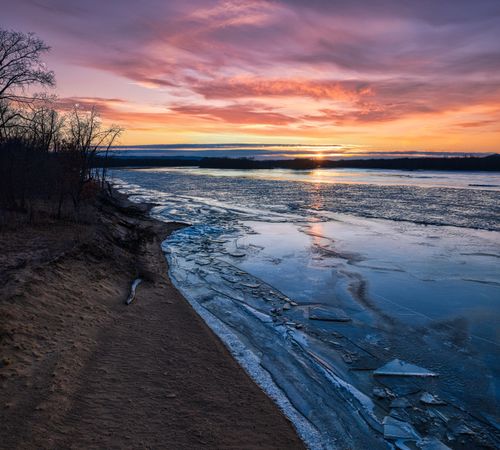 Free Captivating sunset over a frozen river in Reads Landing, MN, with vibrant skies reflected in icy waters. Stock Photo
