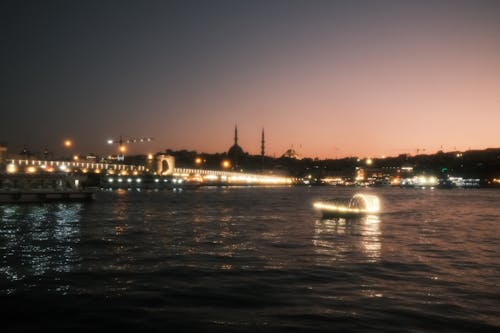 Illuminated Bridge above Water near Night City