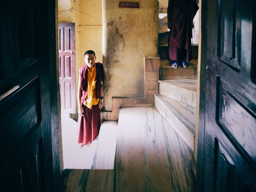 Boy in Yellow and Red Dress Standing on Hallway