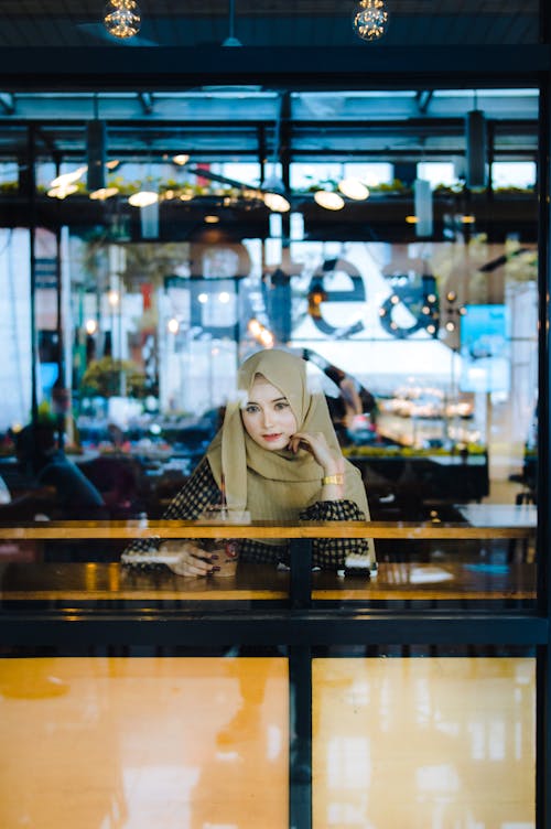 Free Young Woman in Hijab Sitting in Cafe Stock Photo