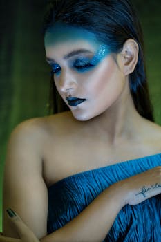 Artistic portrait featuring bold blue makeup and closed eyes for a creative fashion look.