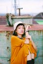 Girl in Hat and Yellow Dress Sitting with Elbows on Knees