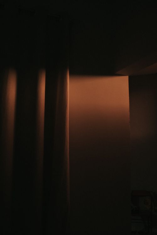 Free Mystical light through curtains casting shadows in a dim room. Stock Photo