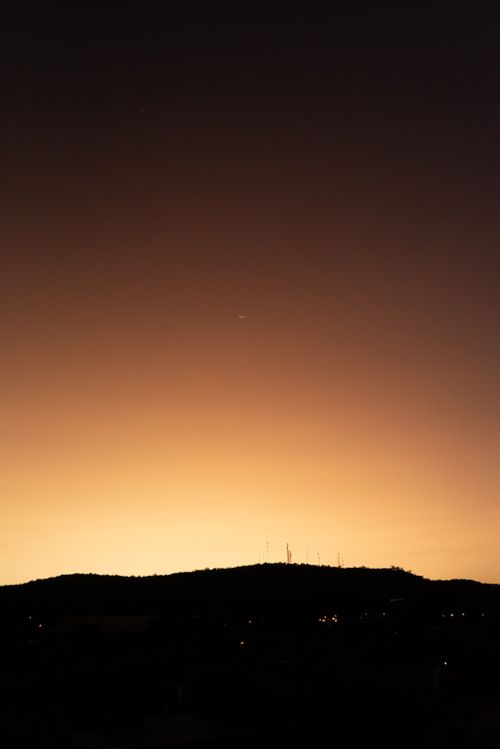 Free Dramatic sky at twilight with a mountain silhouette creates a serene evening scene. Stock Photo