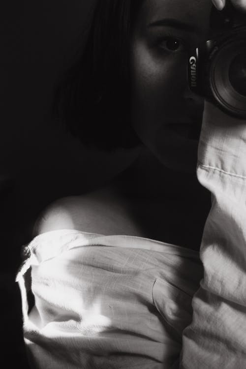 Grayscale Photo of Woman Holding Camera