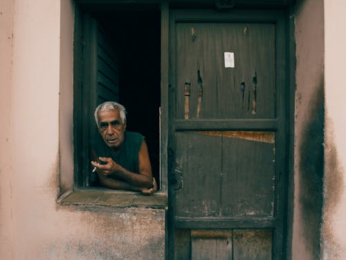 Elderly Man Looking Through Window