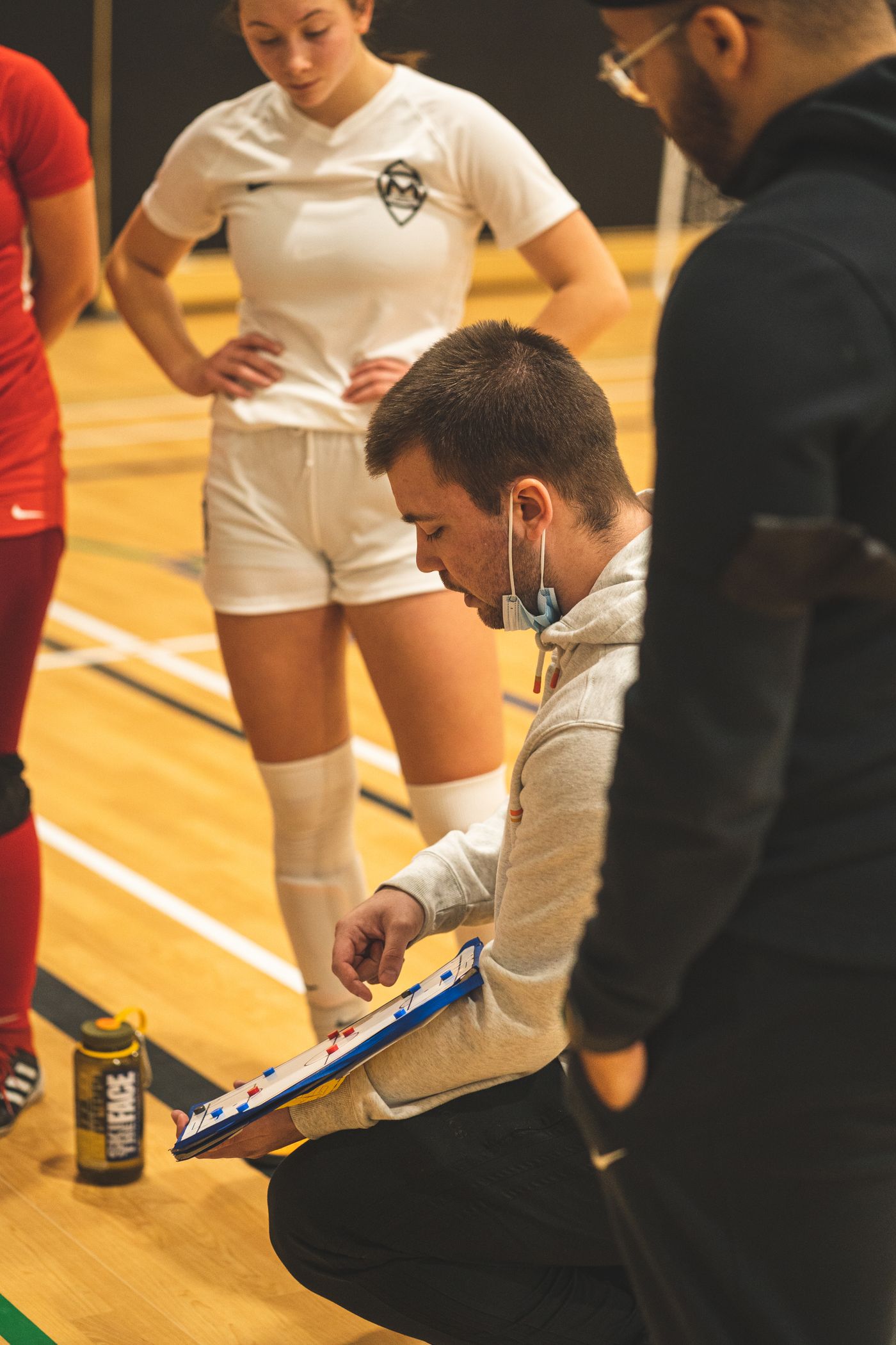 Coach speaking with teenage players during a structured basketball session