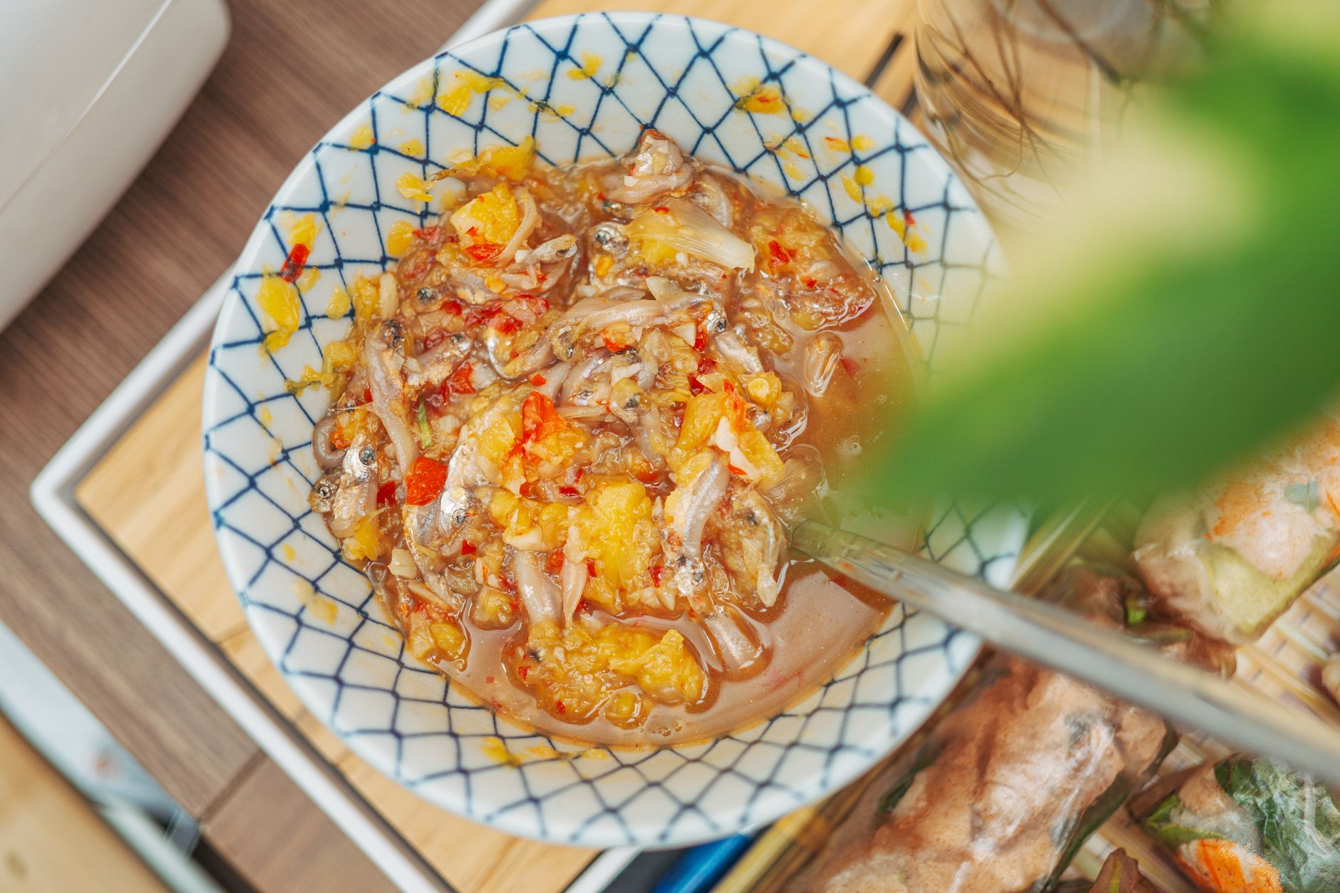 A vibrant chili fish sauce dish served in a decorative ceramic bowl, perfect for adding flavor to meals.