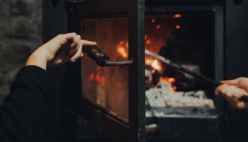 Person Opening a Furnace 