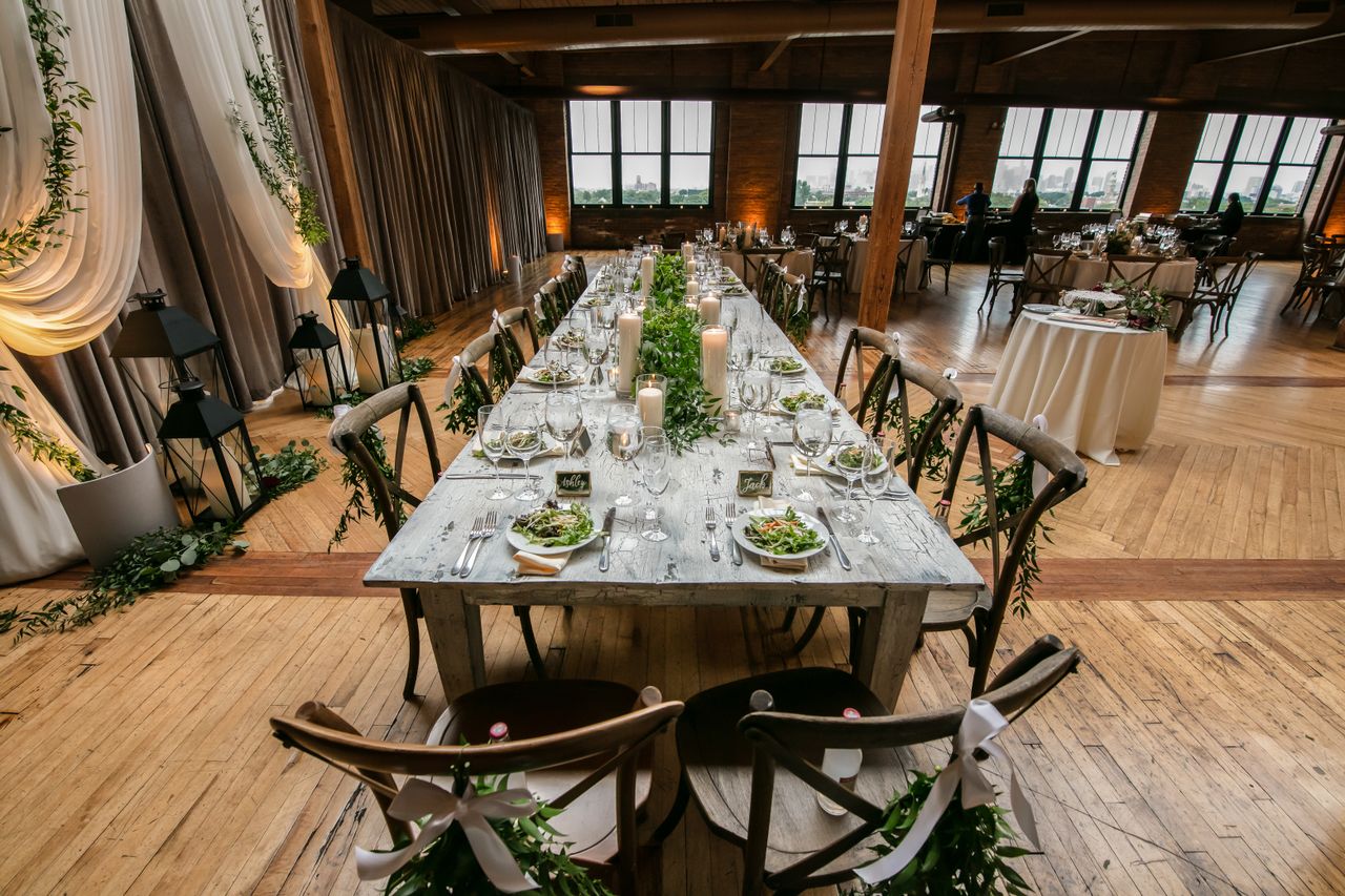Whitewashed wood dining table with cross-back chairs in a bright loft