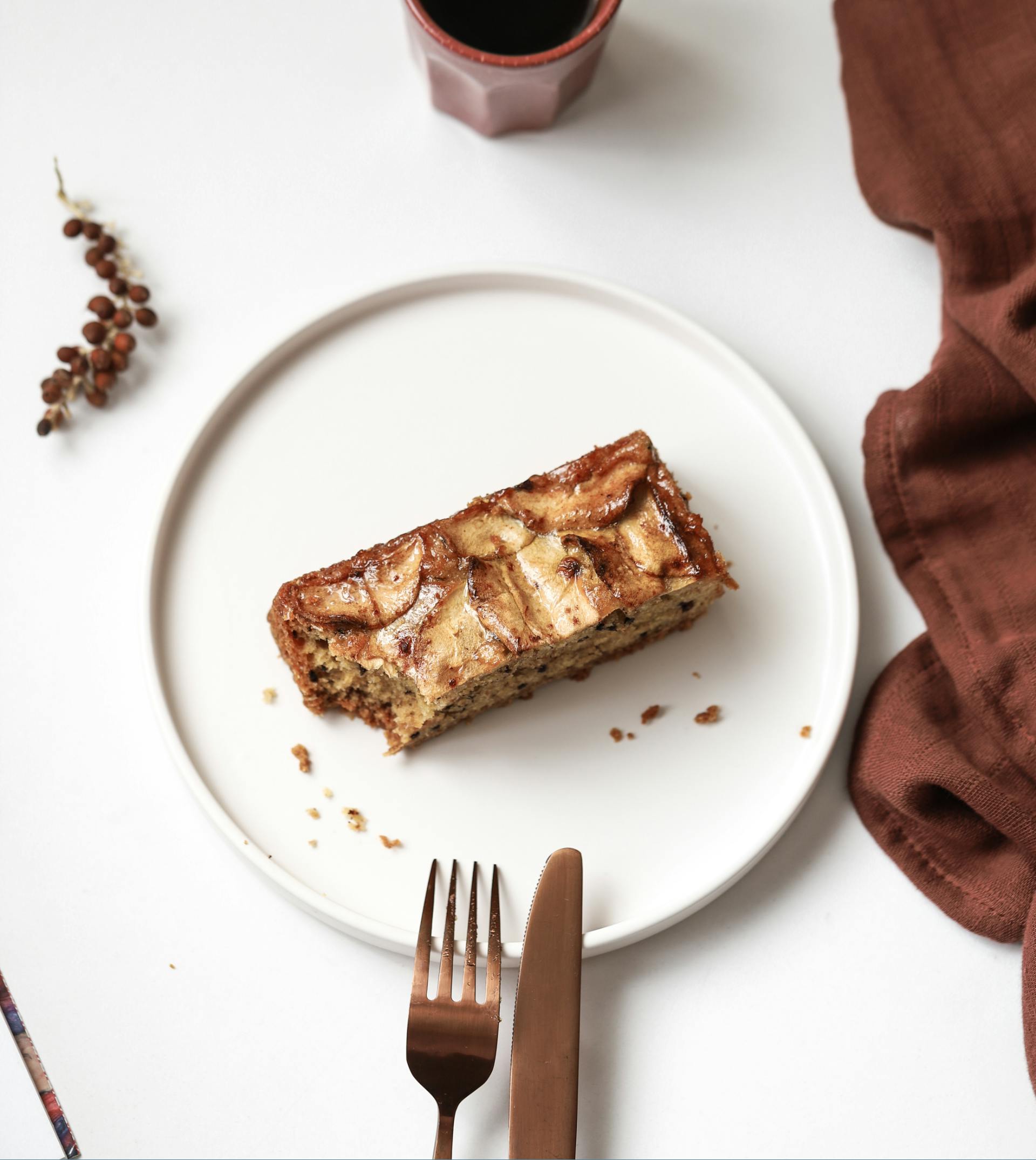 A mouth-watering slice of apple cinnamon bread on a minimalistic white plate.
