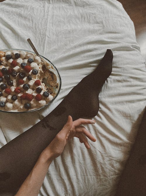 Free Woman Leg and Hand with Cake on Bed  Stock Photo