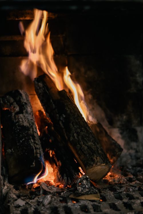Free A close-up view of burning logs in a fireplace with vibrant flames. Stock Photo