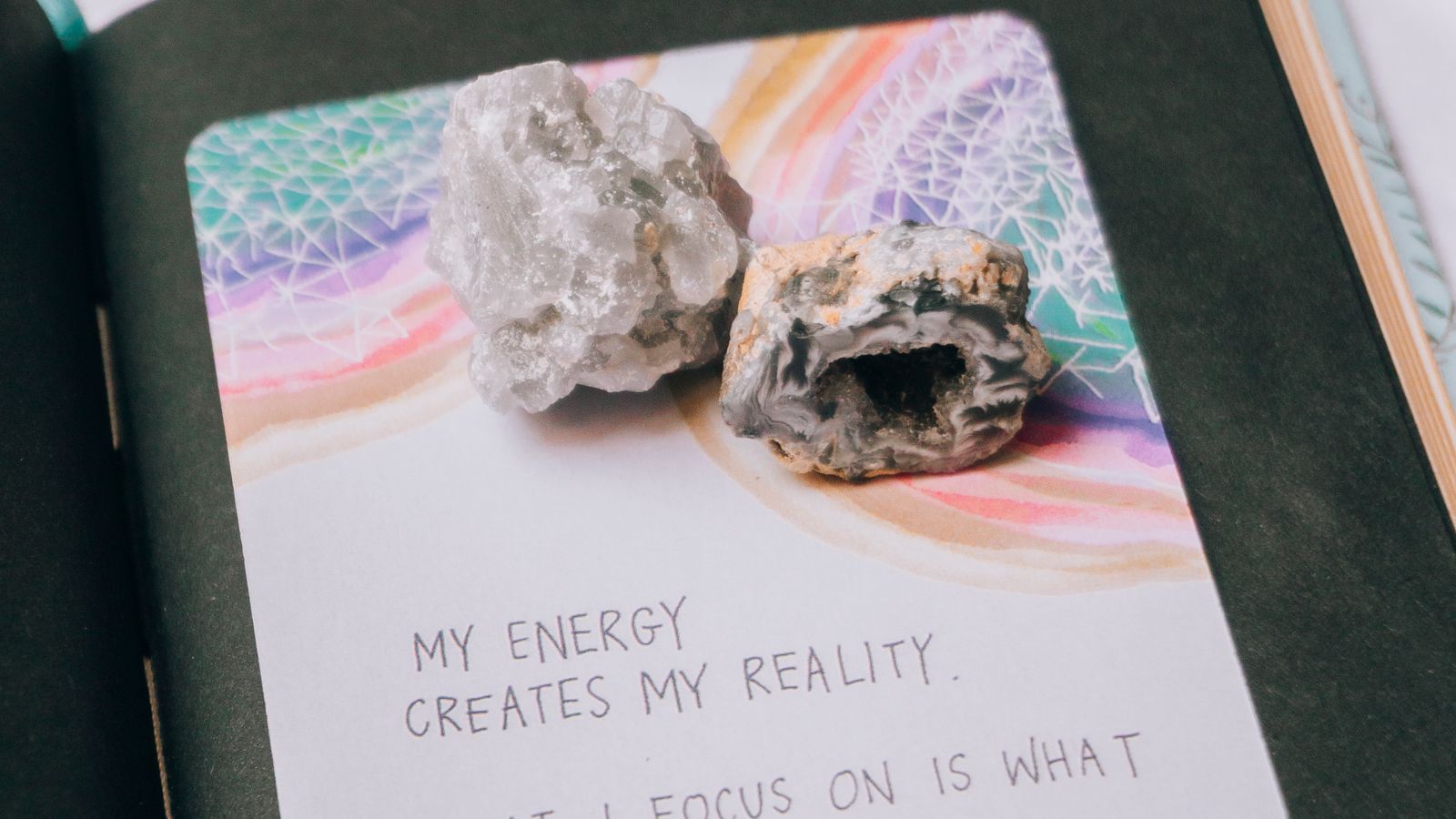 An open journal with crystals and a manifestation quote on the page