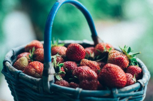 Free Vivid close-up of fresh, juicy strawberries overflowing in a wicker basket. Stock Photo