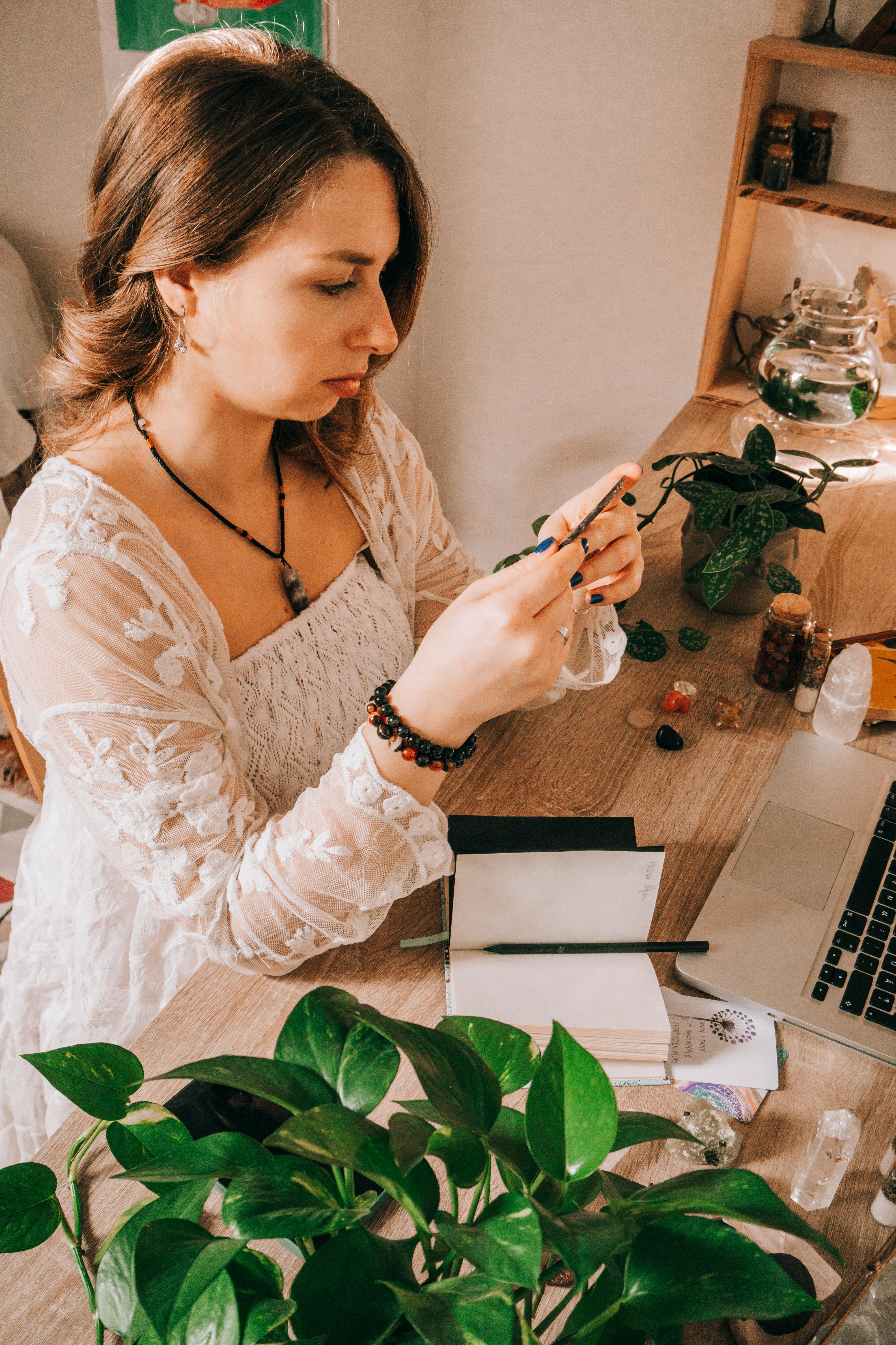 woman sitting by desk with plants