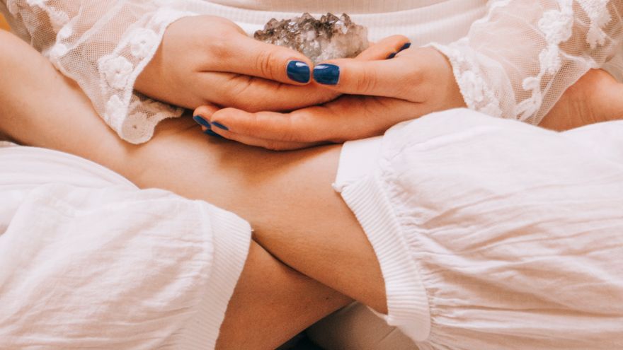 A person meditating with a Tibetan singing bowl and a crystal, representing using the chakra line as a structured reflection and wellness practice