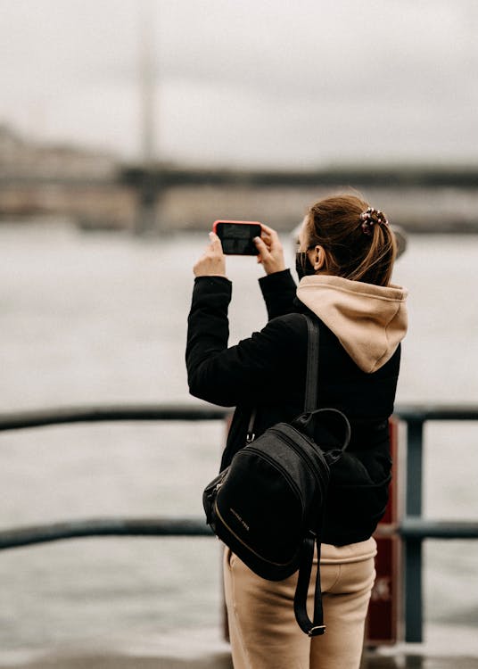 Free 
A Woman in a Hoodie Taking a Picture with Her Smartphone Stock Photo