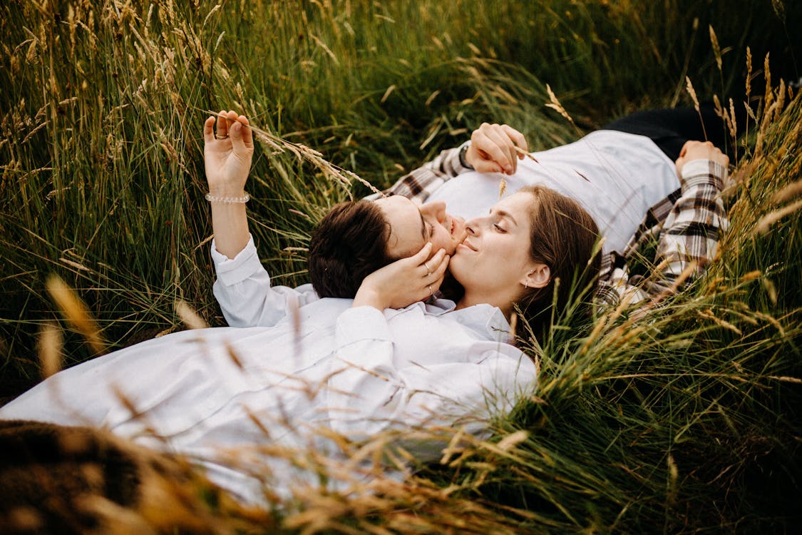 Free Couple Lying on Field Together Opposite Each Other  Stock Photo