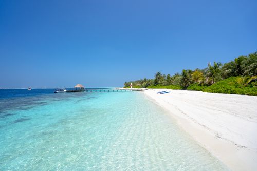 Free Serene tropical beach with crystal clear waters and white sand, perfect for a tranquil getaway. Stock Photo