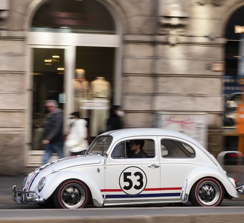 Free A vintage Volkswagen Beetle driving on a busy street in Milan, Italy. Stock Photo