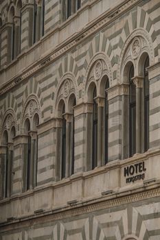 Close-up view of an ornate hotel building facade featuring intricate arched windows.