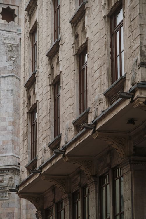 Free Elegant European-style facade showcasing classic stone architecture and ornate designs. Stock Photo