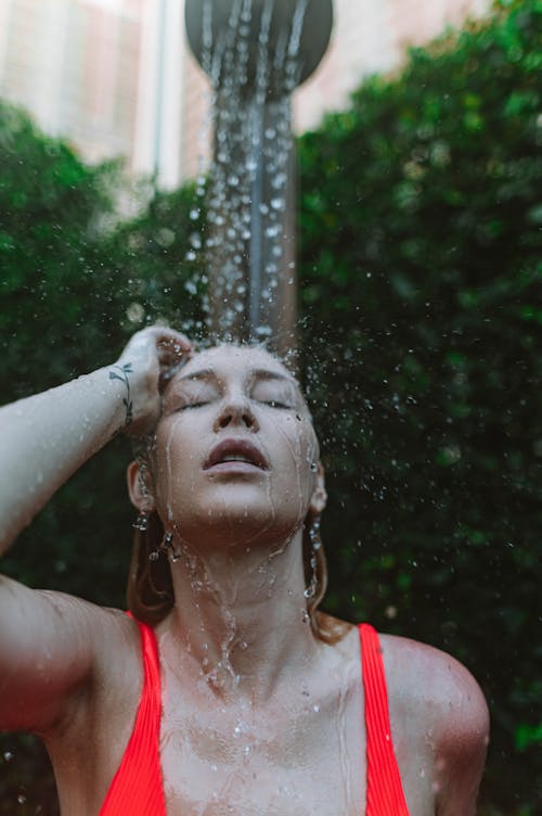 A Woman in a Red Tank Top Taking a Shower