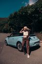 Woman in Black Tank Top and Brown Pants Leaning on Silver Car