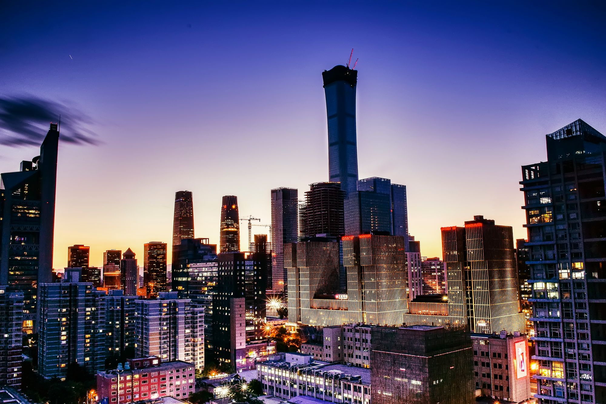 Vibrant cityscape of Beijing's skyline with illuminated skyscrapers at dusk.